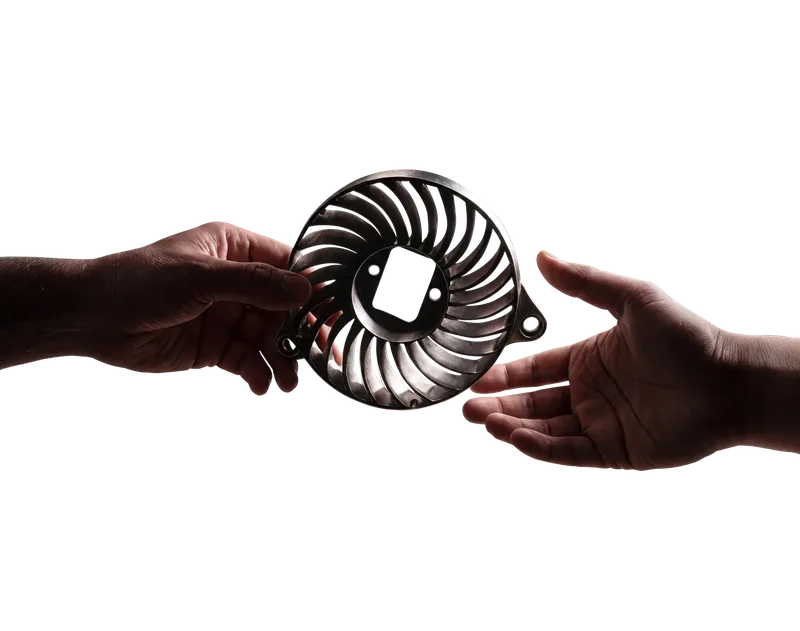 A cast metal impeller held in a hand